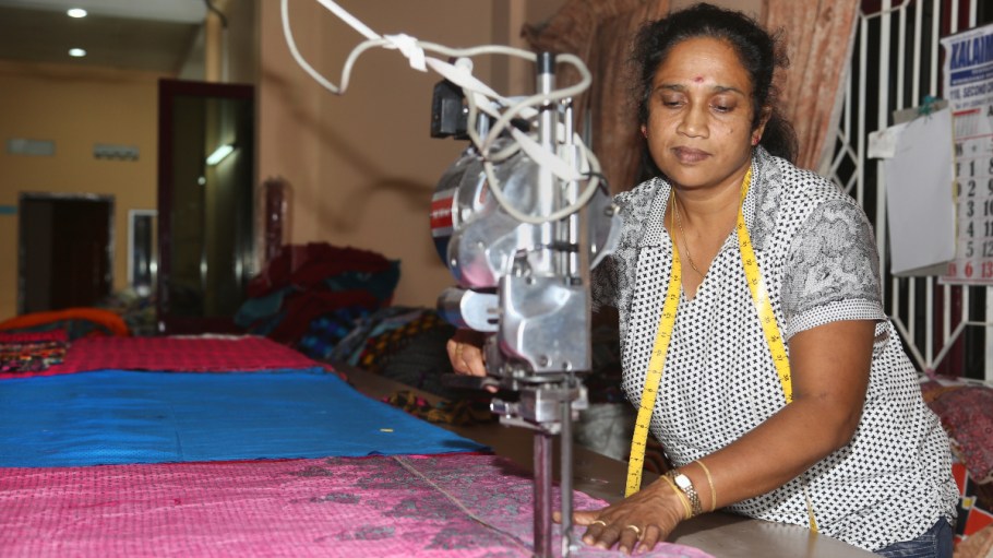 beplay官网娱乐女人使用一台机器来减少织物在瓦武尼亚县的一个服装厂,斯里兰卡。